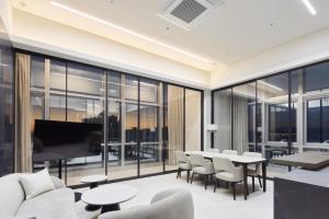 a living room with glass walls and tables and a piano at Palatium Haeundae by SONO Felice in Busan +28 photos