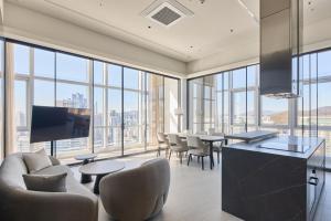 a large room with tables and chairs and large windows at Palatium Haeundae by SONO Felice in Busan