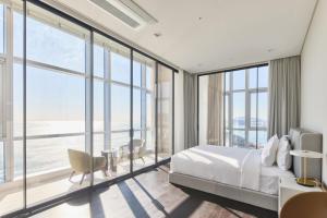 a bedroom with a bed and large windows at Palatium Haeundae by SONO Felice in Busan