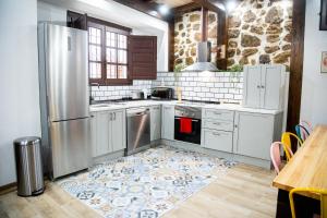 a kitchen with a stainless steel refrigerator and a table at Casa Dana, Losar de la Vera in Losar de la Vera