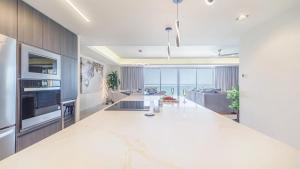 a large white kitchen with a living room and a couch at Two bedroom Suite in Puerto Peñasco