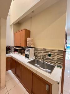 a kitchen with a sink and a microwave at The Cabin Tugu Hostel in Yogyakarta +7 photos