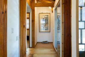 a hallway of a home with wooden flooring and a mirror at HakMinJae Hanok Stay in Seoul