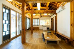 a living room with wooden ceilings and a table at HakMinJae Hanok Stay in Seoul