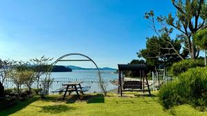 a picnic table and a bench next to a body of water at Seosan View Live in Seosan