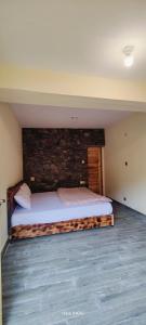 a bedroom with a bed with a brick wall at Hikal Guest House in Gilgit