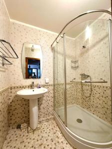 a bathroom with a shower and a sink and a tub at Amar Guest House in Ulaanbaatar
