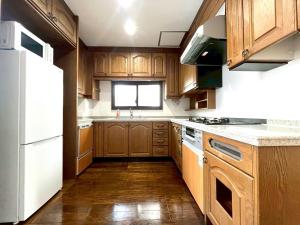 a kitchen with wooden cabinets and a white refrigerator at Yokohama Mega Stay in Yokohama +45 photos