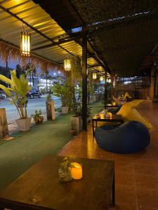 a large room with a bunch of plants and tables at Lemon Inn in Ko Lanta