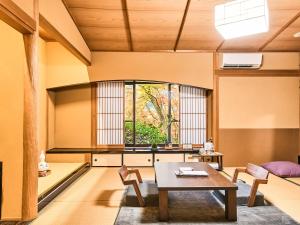 ein Wohnzimmer mit Tisch und Stühlen in der Unterkunft Kirishima Momijidani Seiryuso in Kirishima