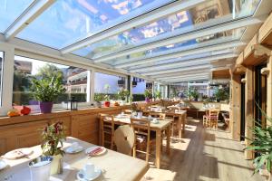 a restaurant with tables and chairs and large windows at Pension Bergsee in Bad Wiessee