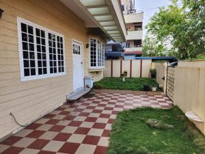 a house with a checkered floor in front of it at Contemporary comfort in Kākināda