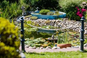 a garden with a pond with a fountain and flowers at Gasper Business & Garden Hotel in Raunheim