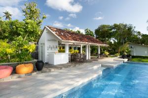 a villa with a swimming pool and a house at The Niche Hikkaduwa - 10 minutes to the beach in Hikkaduwa +13 photos
