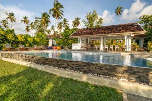 a swimming pool in front of a villa at The Niche Hikkaduwa - 10 minutes to the beach in Hikkaduwa