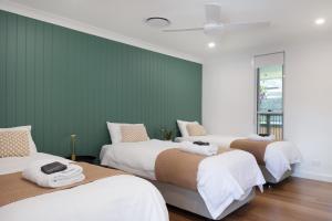 three beds in a room with green walls at Monty's House in Montville