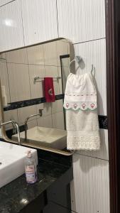 a bathroom with a mirror and a sink and a towel at Hospedagem cama e café in Domingos Martins