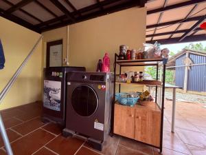 a kitchen with a washing machine and a shelf at Fish Farm Homestay in Yên Bái