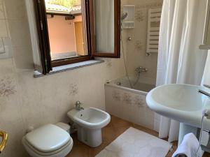 a bathroom with a toilet and a sink and a tub at Casa Vacanze a Luino - Casa di Adele in Luino +14 photos