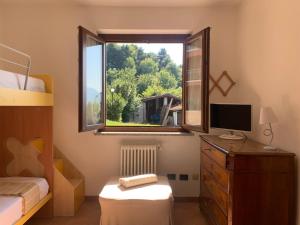 a bedroom with a window and a desk with a television at Casa Vacanze a Luino - Casa di Adele in Luino