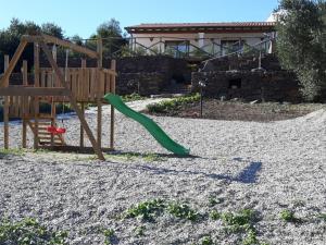 a playground with a green slide in the sand at Agriturismo Su Barcu in Cala Gonone