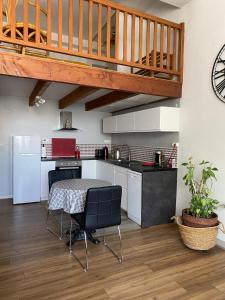 a kitchen with a table and a wooden staircase at Appartement Hyper Centre in Limoges