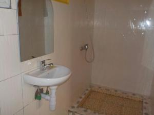 ein Badezimmer mit Waschbecken, Spiegel und Dusche in der Unterkunft Rem Hotel in Fianarantsoa