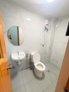 a white bathroom with a toilet and a sink at Guest hotel Palestina Pili in Pili