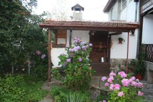 una pequeña casa con un porche con flores en Todorova House en Zlatograd