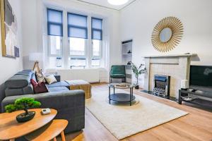 a living room with a couch and a fireplace at Cambridge Apartment in Glasgow