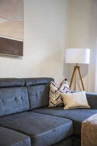 a blue couch with pillows on it in a living room at Cambridge Apartment in Glasgow