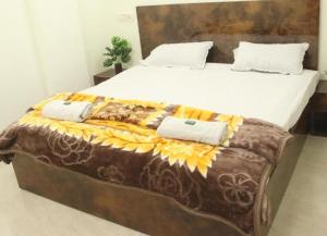 ein großes Bett mit zwei Kissen darauf in der Unterkunft Hotel Pariwar in Aurangabad