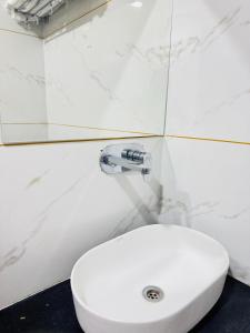 a bathroom with a white toilet and a sink at Sairam Residency in Ellora