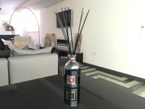 a bottle with sticks in it sitting on a table in a living room at Residenza RoMa in Tropea