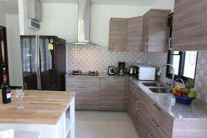 eine Küche mit Holzschränken und einer Arbeitsplatte in der Unterkunft Baan Ping Tara Tropical Private Pool Villa in Ao Nang Beach