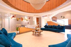 a living room with blue couches and a table at Kaara Gurgaon in Gurgaon
