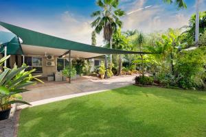 an exterior view of a house with a green yard at Nature's Nest - Pool - SPA - Outdoor Kitchen and Dining in Leanyer