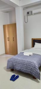 a bedroom with a bed with blue slippers on the floor at Viki homestay in Dimapur