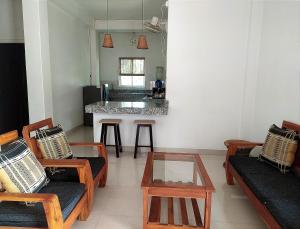 a living room with chairs and a table and a kitchen at Viki homestay in Dimapur