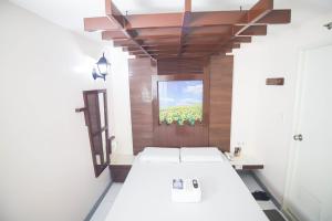 a room with three beds and a television in it at Astrotel Calamba in Calamba