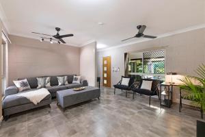 a living room with a couch and a table at Nature's Nest - Pool - SPA - Outdoor Kitchen and Dining in Leanyer