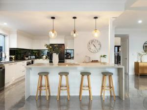 a kitchen with a large island with bar stools at Capri Garden Stay in Gold Coast