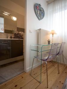 a glass table and a chair in a kitchen at La Rosière de Marcq in Marcq-en-Baroeul