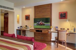 a hotel room with a bed and a tv at Hotel Tamilnadu Pandiyan Madurai in Madurai