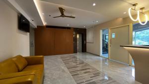a living room with a couch and a ceiling fan at Cloud Nine Hotel in Kottayam