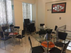 uma sala de jantar com mesas, cadeiras e janelas em Hostal Gold Star em Tacna