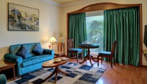 a living room with a blue couch and a table at Hotel Tamilnadu Pandiyan Madurai in Madurai