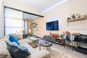 a living room with a couch and a tv at Piazza Pontida - City Center - Meliora Apartments in Bergamo