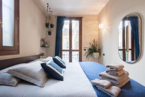 a bedroom with a large bed with towels on it at Piazza Pontida - City Center - Meliora Apartments in Bergamo