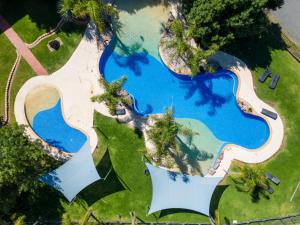 an aerial view of a pool with palm trees at Tasman Holiday Parks - Merool on the Murray in Echuca